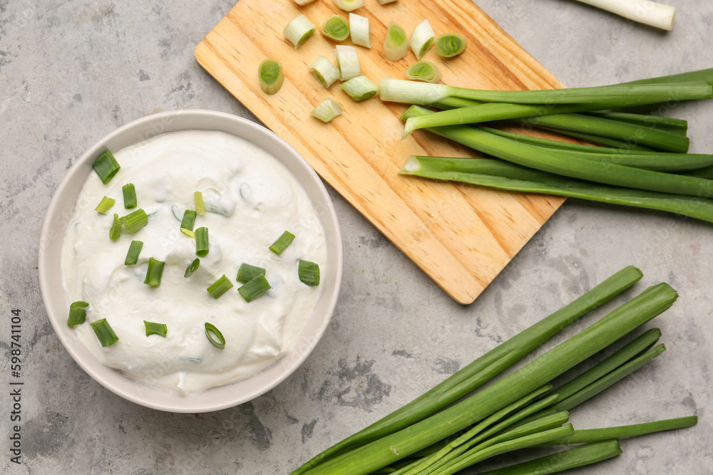 Bowl of tasty sour cream with green onion on grunge background Bowl of tasty sour cream with green onion on grunge background