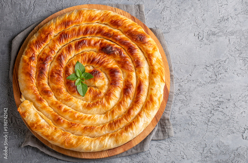 Traditional Turkish pastry with spinach. (Turkish Name: Ispanakli Kol Boregi, Bosnak boregi). Handmade pastry with spinach filling. photo