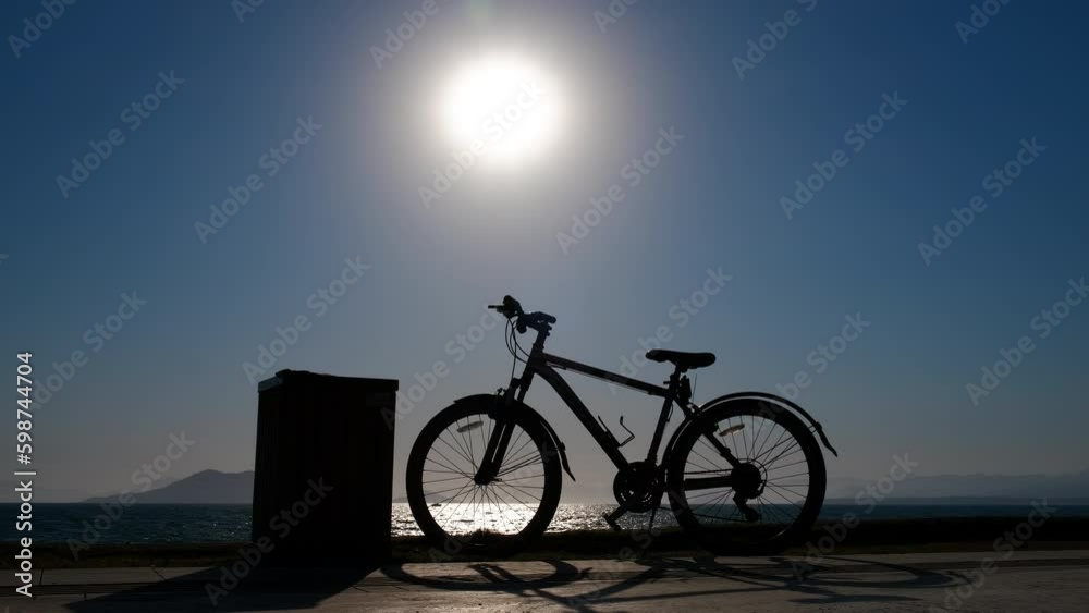 Lonely bike in the evening on the beach. Bicycle silhouette on the background of the sun. Generative AI Lonely bike in the evening on the beach. Bicycle silhouette on the background of the sun. Generative AI