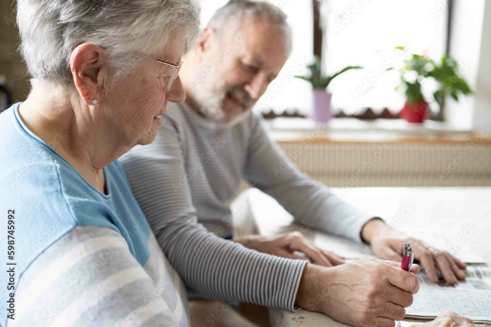 Obraz premium Grey haired senior couple making sudoku in the kitchen 