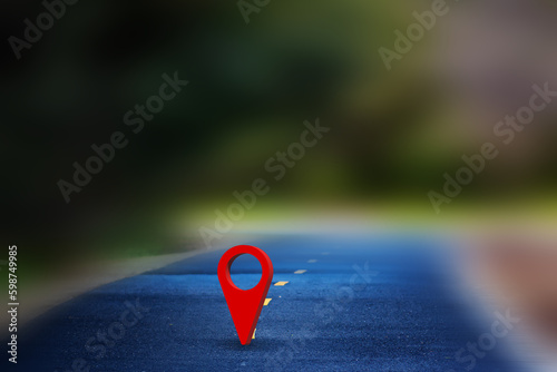 Red GPS pin on the asphalt road and nature landscape