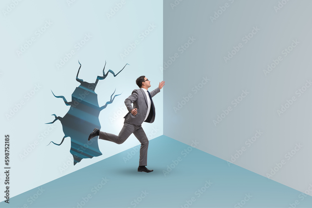 Fototapeta premium Businessman breaking through the wall