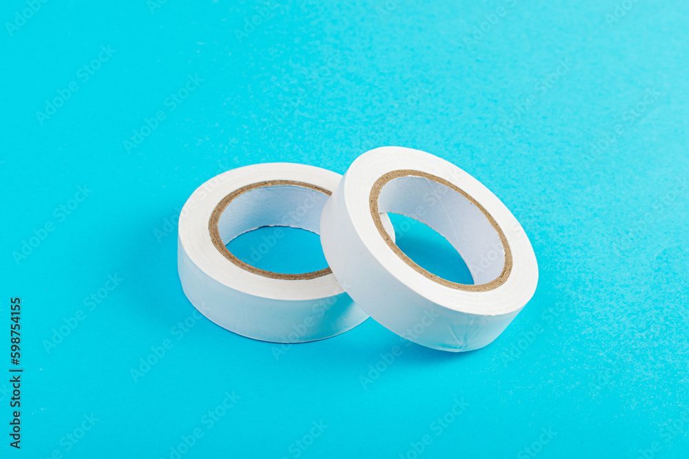 White Electrical Tape, Plastic Duct Tape Rolls, Colored Adhesive Tapes on Blue Background White Electrical Tape, Plastic Duct Tape Rolls, Colored Adhesive Tapes on Blue Background