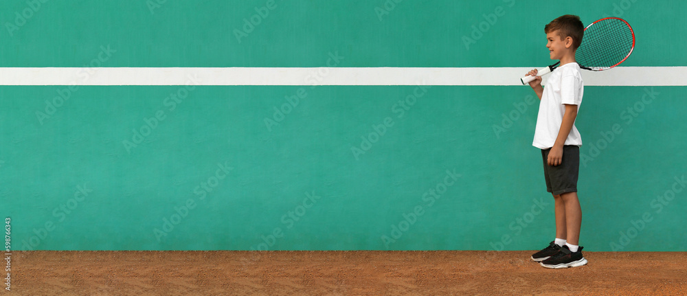 Cute little boy near green wall on tennis court. Banner design with space for text