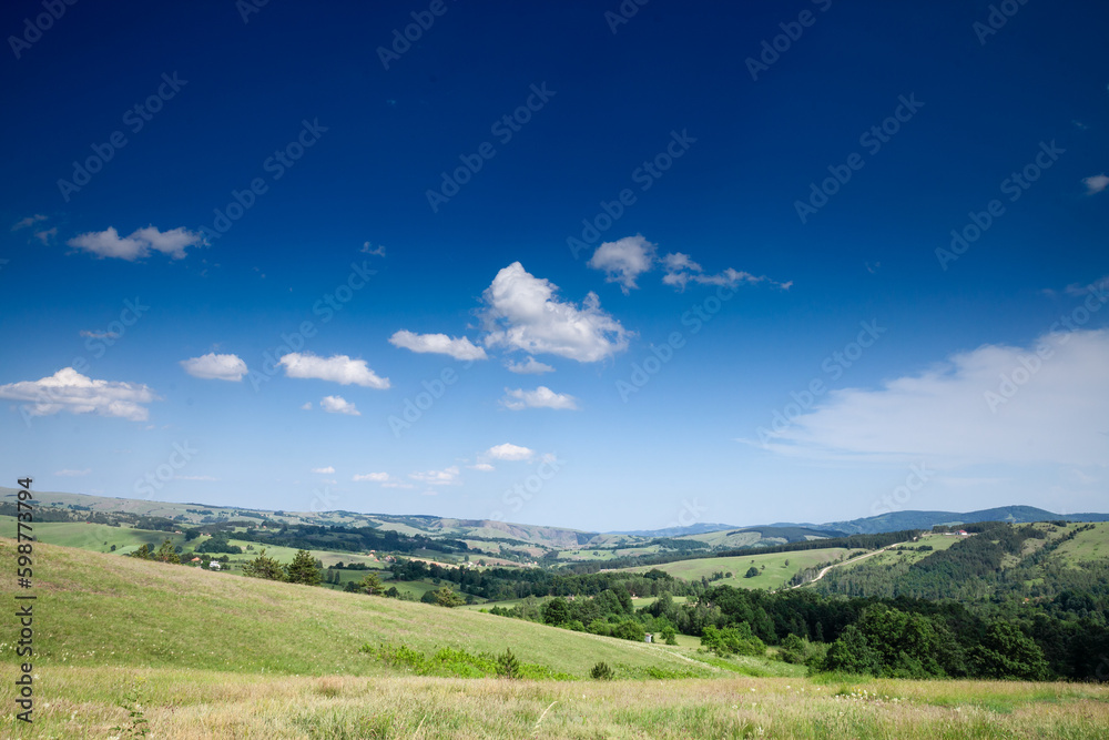 panorama seen from above of the divcibare mountains and the tometino polje plain in Divcibare, a major mountain resort of Serbia, surrounded by fir trees and pine forest. panorama seen from above of the divcibare mountains and the tometino polje plain in Divcibare, a major mountain resort of Serbia, surrounded by fir trees and pine forest.