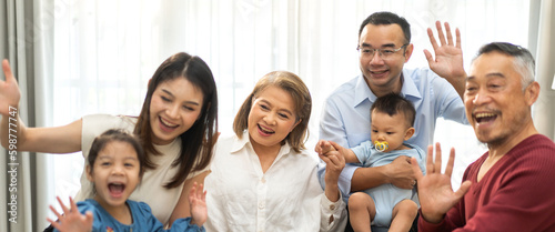 Portrait of happy love asian grandfather with grandmother playing with asian baby and little cute girl say bye, hallo.Big family love with father and mother smiling together.Family and togetherness