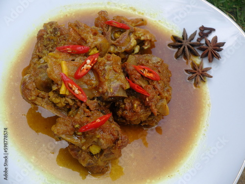 Indonesian food made of lamb meat and bone. It's very famous food in Indonesia. Tongseng kambing. lamb curry with soy sauce.  photo