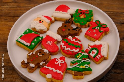 tasty Christmas cookies on a white ceramic plate. delicious colorful Christmas cookies. kue kering natal. Santa clause. Christmas tree. ginger cookies. 