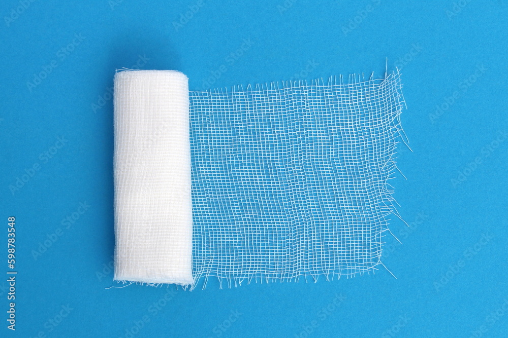 Obraz premium A white medical bandage lies on a blue background. 
