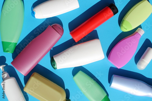 Many different bottles of cosmetics are on a blue background. photo