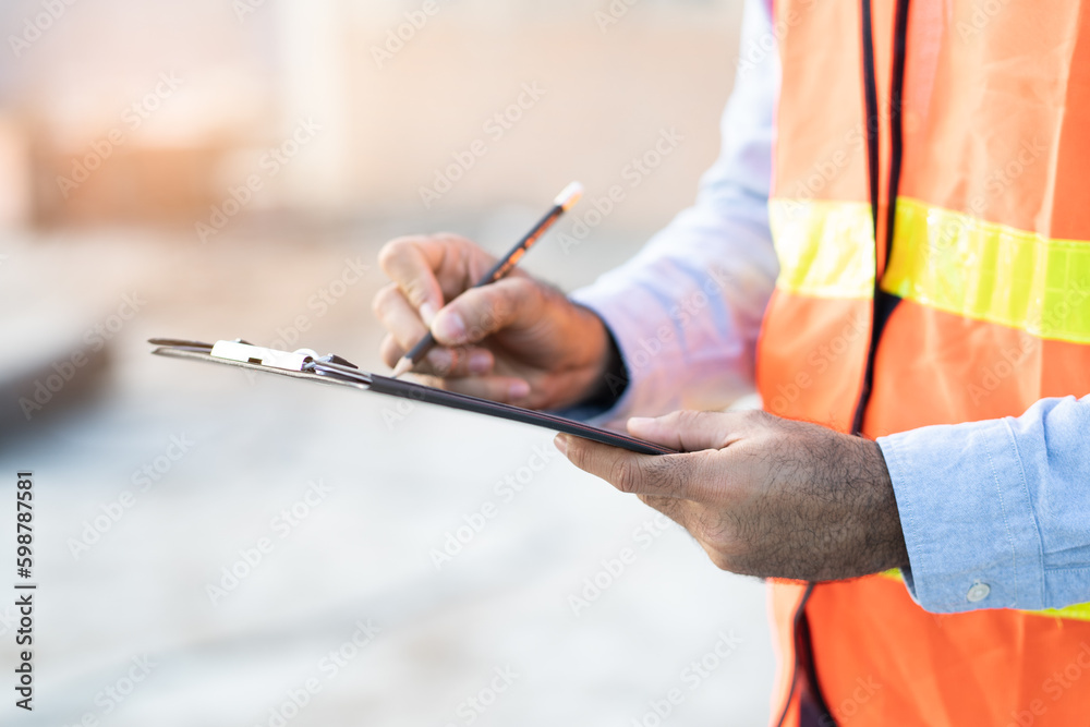 Obraz premium Asian inspector checking structure of new property and taking note in the clipboard for review and fix the house before sell to client