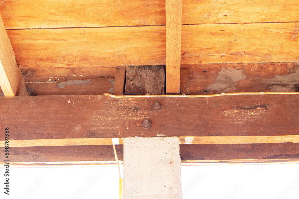 Under nut structure to fix concrete column to large wooden brown beam. Construction of rural houses in Thailand. Tightening with large screws with washer Simple construction design, strong for housing