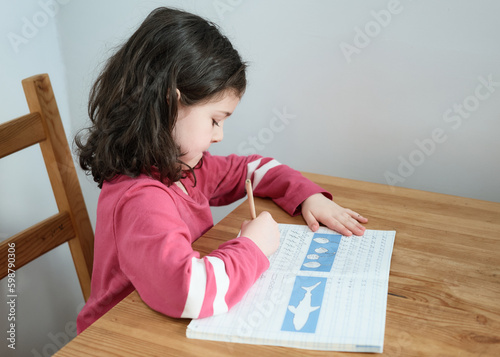 young girl doing her homework in the kitchen