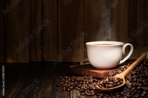 Freshly brewed coffee. Coffee cup or mug arranged on a black wooden table with roasted coffee beans. Espresso mocha cappuccino barista on dark background