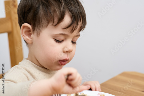 young boy eating oatmeal for breakfast