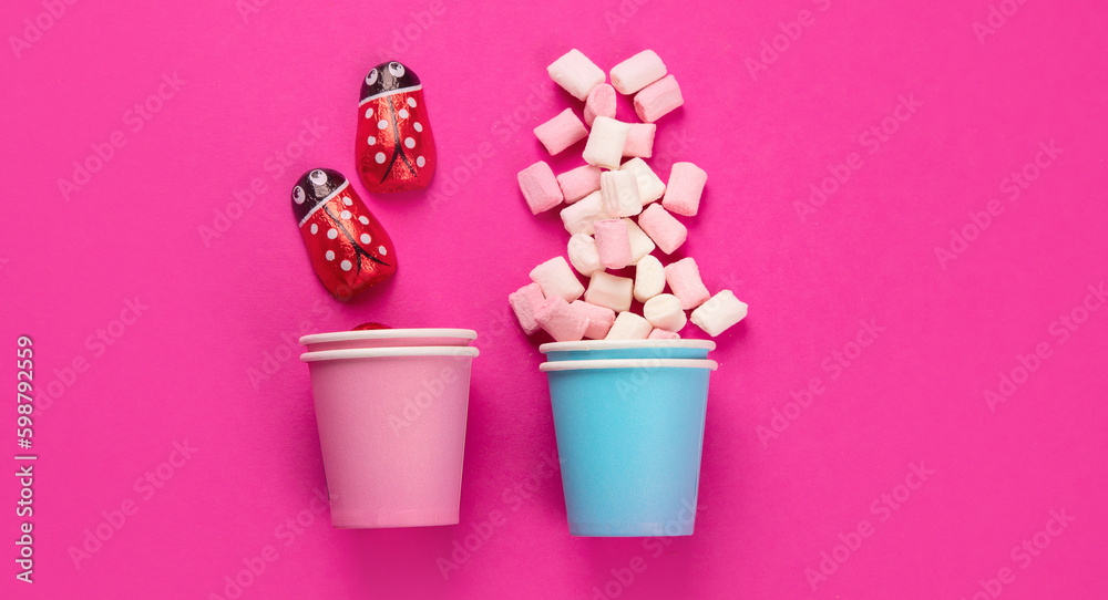 Paper cups with different candies on pink background. Paper cups with different candies on pink background.