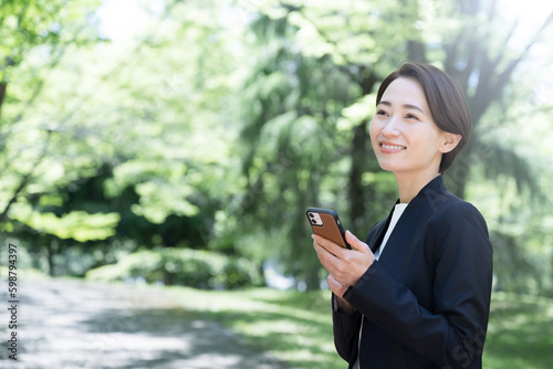 Woman talking on a phone in a suit in backlight Business changing jobs, hiring, appointing women, etc. Copy space available.	 photo