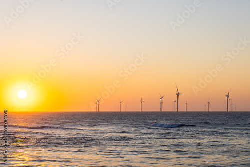 Wind turbine field over the sea in the evening