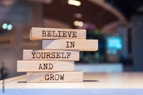 Wooden blocks with words 'Believe in yourself and grow'.