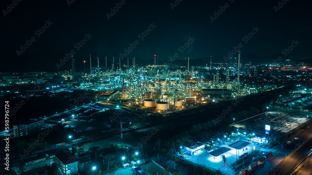 Oil refinery plant from industry zone, Aerial view oil and gas petrochemical industrial, Refinery factory oil storage tank and pipeline steel at night over lighting,