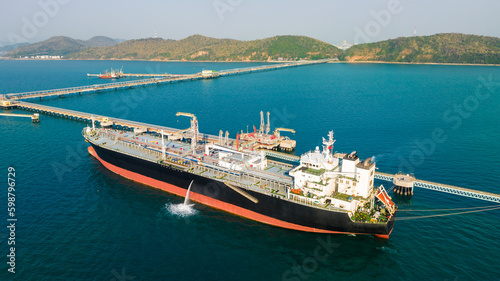 crude oil floating station in sea, bridge pipeline load unloading crude oil from oil ship transport, industry business transportation by container ship open sea, aerial view from drone