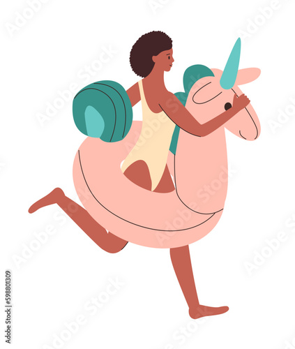 African girl runs with an inflatable circle in form of unicorn. Colorful rubber inflatable swimming ring.