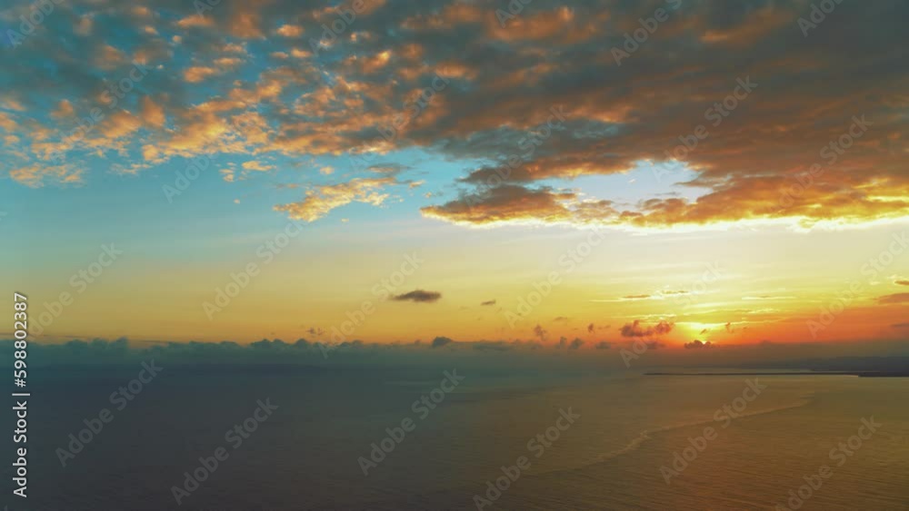Orange sunset over turquoise sea on a tropical summer evening. Sea waves with sunset reflections. Calm sea water. Blue ocean under a turquoise sky with orange clouds. Twilight over the sea. Orange sunset over turquoise sea on a tropical summer evening. Sea waves with sunset reflections. Calm sea water. Blue ocean under a turquoise sky with orange clouds. Twilight over the sea.