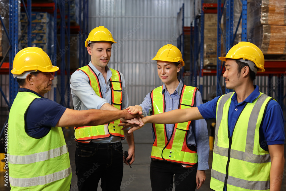Group of engineer or worker in protective suit with hardhat standing and stacking hands celebrate successful together or completed deal commitment at heavy industry manufacturing factory or warehouse Group of engineer or worker in protective suit with hardhat standing and stacking hands celebrate successful together or completed deal commitment at heavy industry manufacturing factory or warehouse