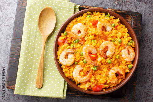 Yellow rice with shrimps arroz con camarones close-up in a bowl on the table. horizontal top view from above