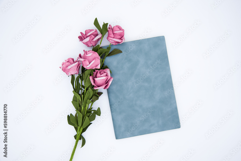 Roses and notebook on white background