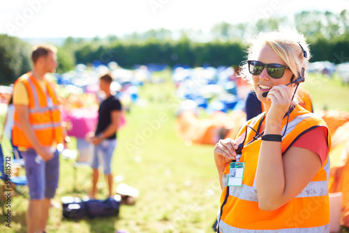 Fototapeta Festival security, communication and a woman outdoor on a grass field for safety at a music concert
