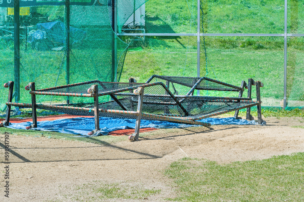Baseball netted backdrops stacked at home base in urban park. Baseball netted backdrops stacked at home base in urban park.