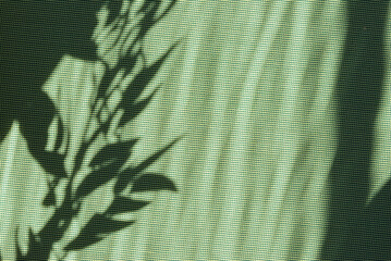 Bright green summer or spring natural background with copy space, aesthetic sun light floral leaves shadows on green textile backdrop