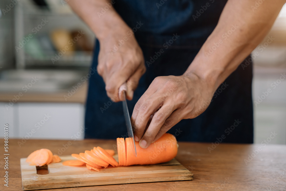 Male prepares cooking healthy food from fresh vegetables and fruits in kitchen room. Male prepares cooking healthy food from fresh vegetables and fruits in kitchen room.