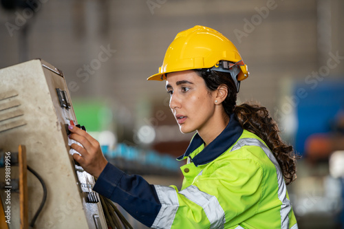 young woman engineer in uniform inspection warehouse and check control heavy machine construction installation in industrial factory. technician worker check for repair maintenance operation system