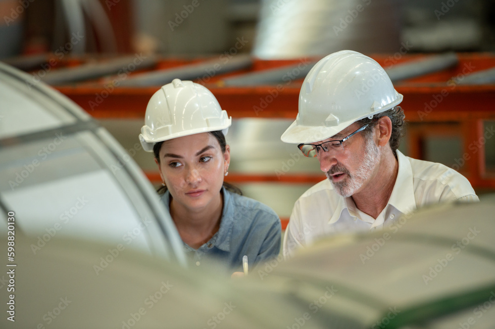 woman engineer assistant secretary in helmet inspection check control heavy machine construction installation in industrial factory with boss manager. Boss and partnership check maintenance factory