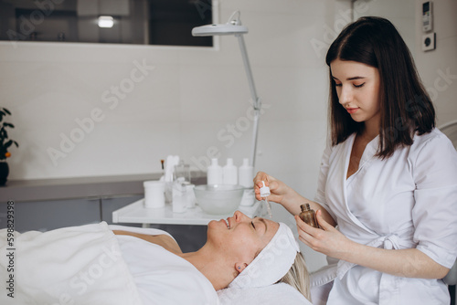 A female cosmetologist holds a pipette with essential oil before aromatherapy and massage to the patient. aromatherapy.Close-up