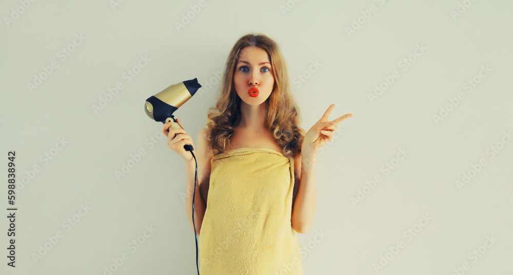 Portrait of happy smiling young woman drying wet hair in wrapped bath towel after taking a shower Portrait of happy smiling young woman drying wet hair in wrapped bath towel after taking a shower
