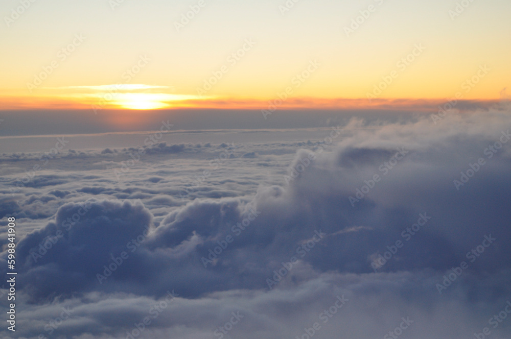 A sunset or a sunrise above clouds, view from the airplane to the skyline on an early morning or evening.