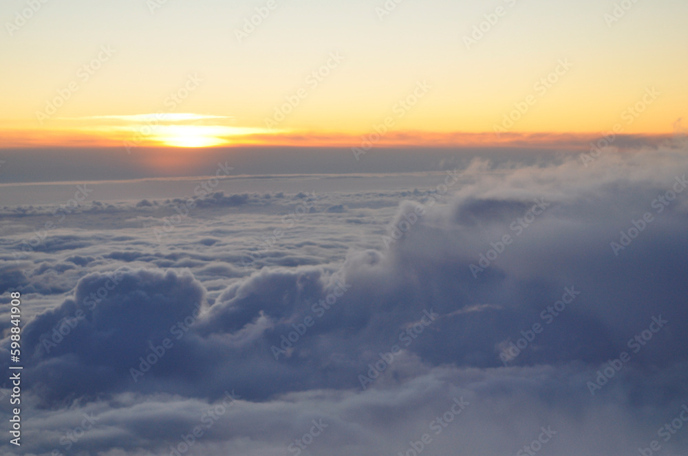 A sunset or a sunrise above clouds, view from the airplane to the skyline on an early morning or evening. A sunset or a sunrise above clouds, view from the airplane to the skyline on an early morning or evening.