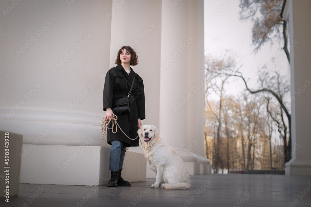 Beautiful girl with her golden dog on street