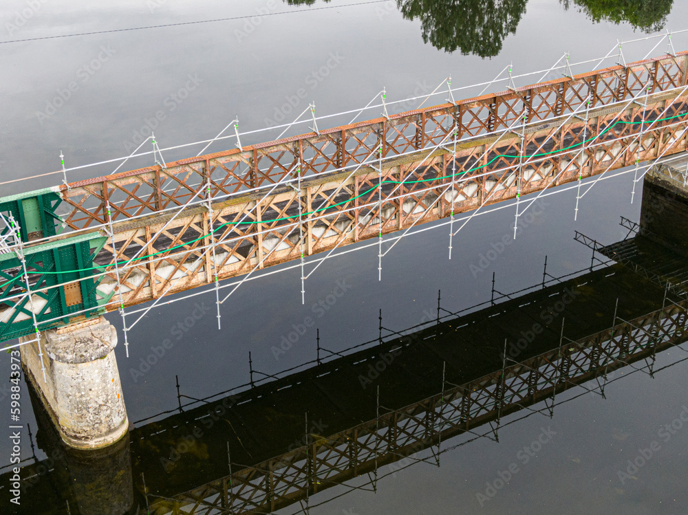 Fototapeta premium Scaffolding used for maintenance or restoration work on a small bridge over a large river the Cher