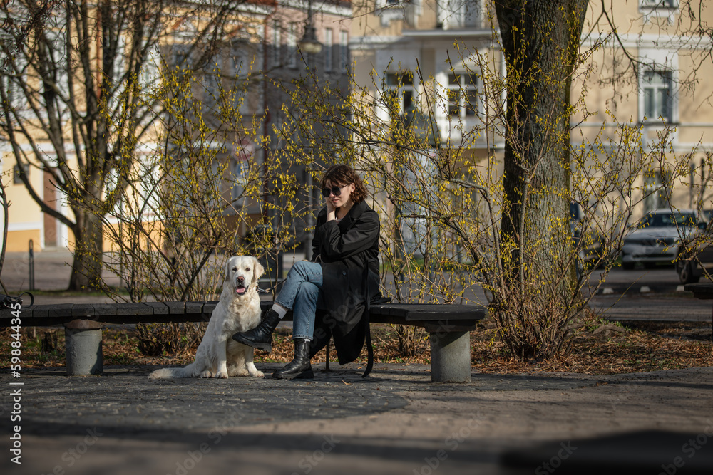 Cute funny girl portrait with her golden dog on street