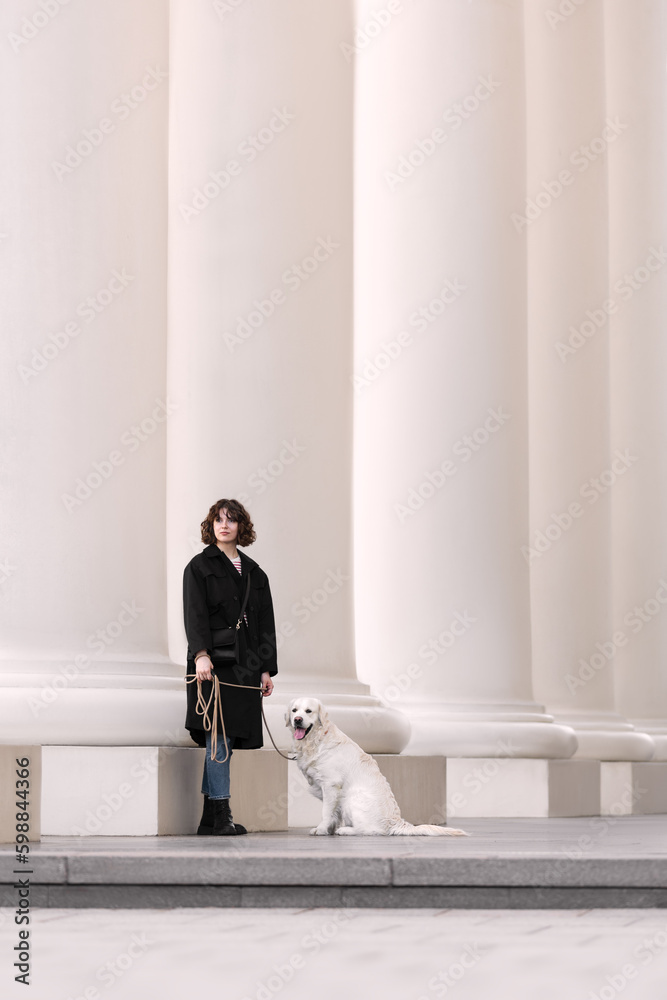 Beautiful girl with her golden dog on street
