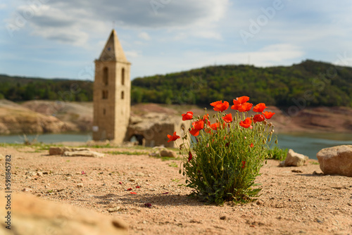 Sau, Spain - 28 April 2023: An old bell tower is seen at the Sau reservoir as the drought caused by climate change causes water shortages in Spain and Europe.