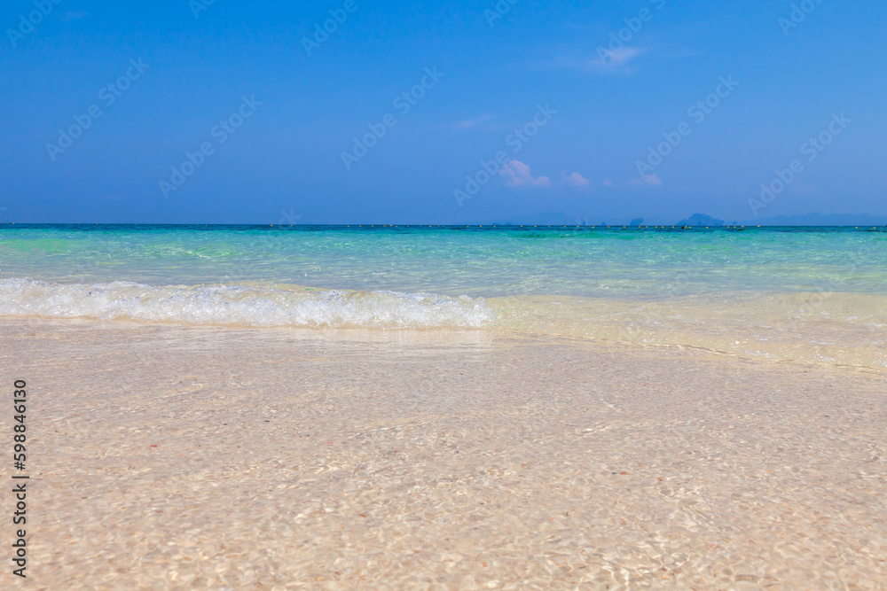 Clean yellow sand on the coast of Bamboo island in Thailand with clear turquoise water and blue sky on a hot day. Travel and vacation in Thailand while on holidays.