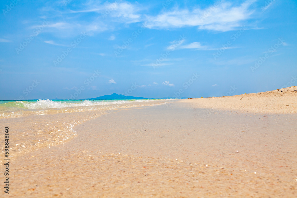 Clean yellow sand on the coast of Bamboo island in Thailand with clear turquoise water and blue sky on a hot day. Travel and vacation in Thailand while on holidays.