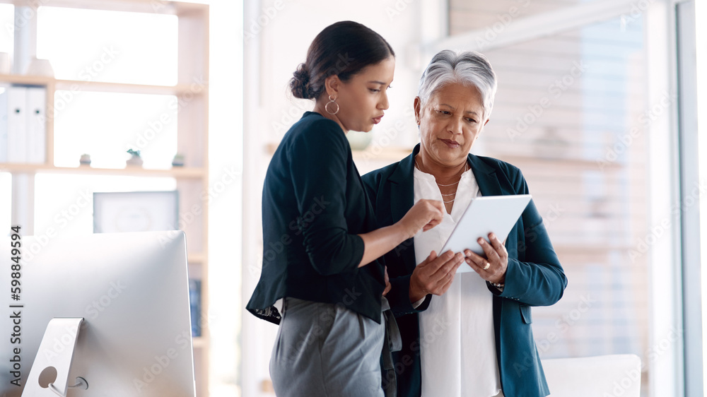 Success is always their frame of reference. two businesswomen working together on a digital tablet in an office. Success is always their frame of reference. two businesswomen working together on a digital tablet in an office.