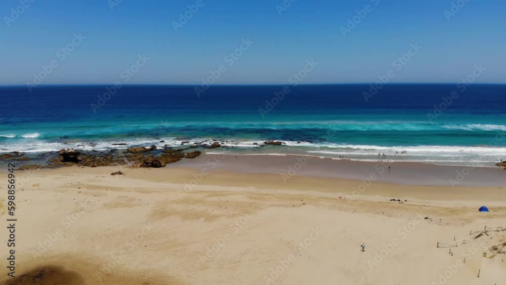 Ascending aerial view of people on a calm beach, sunny day in Australia Ascending aerial view of people on a calm beach, sunny day in Australia