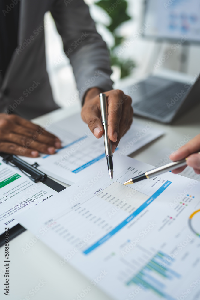 A group of business analysts discuss the summary graph report on business expenses and work information about the company's financial statements.